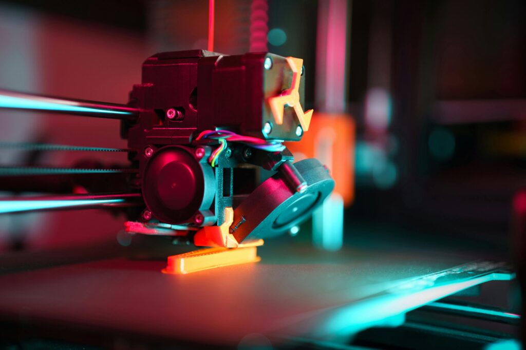 Close-up of a 3D printer in action with neon lighting, showcasing technology in prototyping.